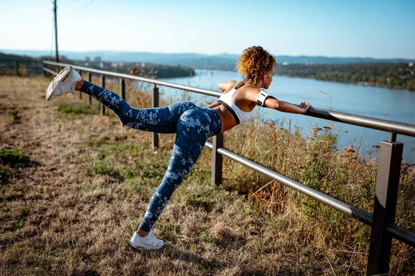 Giovane Donna Corridore Urbano Con Cuffie Facendo Esercizi Stretching Vicino — Foto Stock
