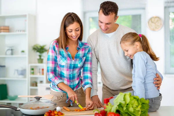 国内台所で健康的な食事を調理している若い家族 — ストック写真