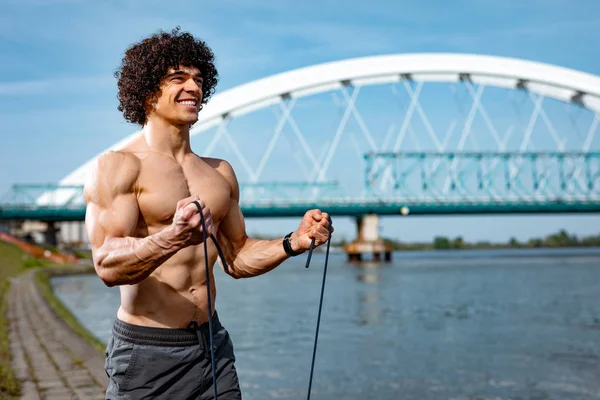 裸の胴体と弾性ゴムバンド運動を行うと筋肉の若い男 — ストック写真
