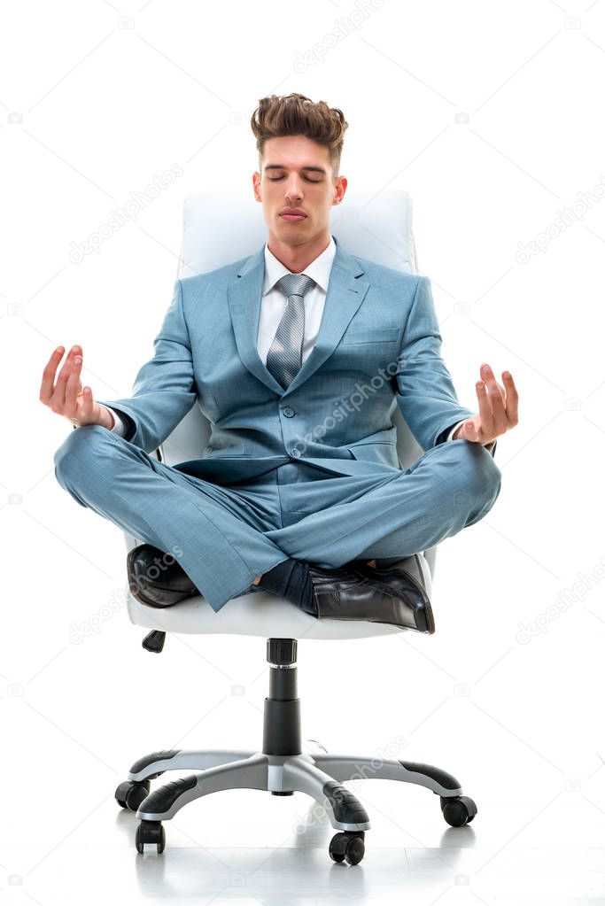 Relaxed businessman doing yoga on office chair isolated on white background