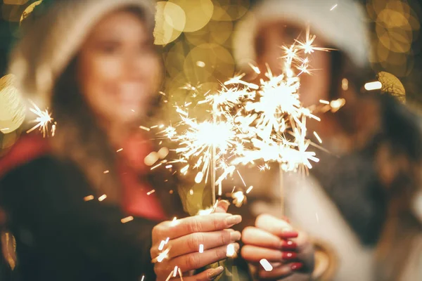 Cheerful Young Female Friends Holding Sparklers Having Fun Holiday Winter — Stock Photo, Image