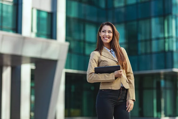 漂亮的年轻成功的微笑的女人正在城市的背景下走过办公区 — 图库照片
