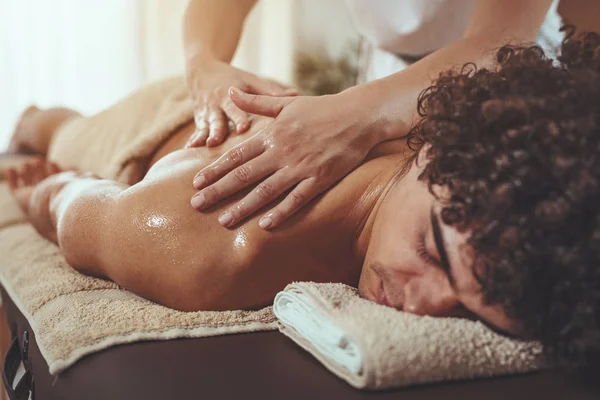 Schöner Mann Legt Sich Auf Massagetisch Und Bekommt Gesunde Rückenmassage — Stockfoto