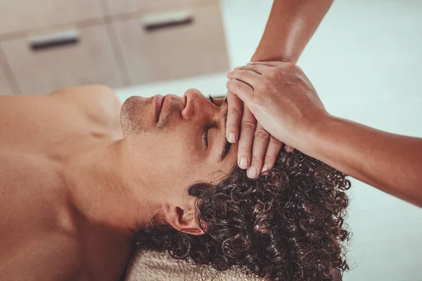 Schöner Mann Legt Sich Auf Massagetisch Und Bekommt Gesunde Gesichtsmassage — Stockfoto