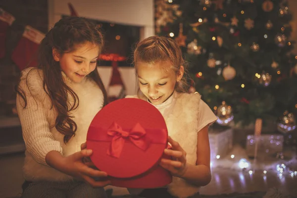 Δύο Χαμογελαστά Κορίτσια Κάθονται Στο Πάτωμα Δίπλα Στο Χριστουγεννιάτικο Δέντρο — Φωτογραφία Αρχείου