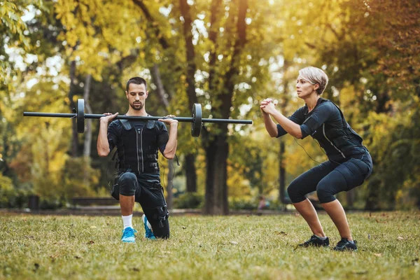 Vacker Kvinna Och Hennes Partner Gör Ben Övningar Parken Tillsammans — Stockfoto