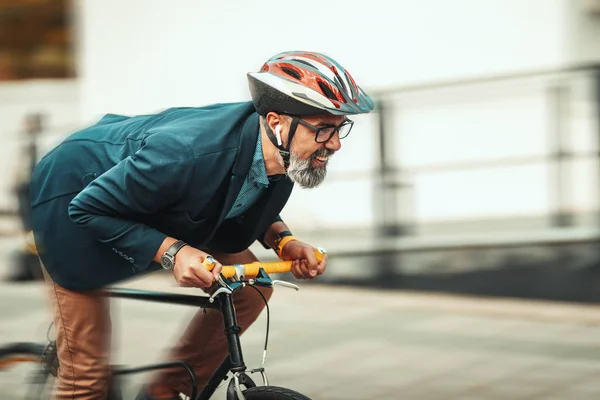 自転車で事務所に行くのはハンサムなカジュアルな中年のビジネスマンです 彼は遅れているので急いでいる — ストック写真