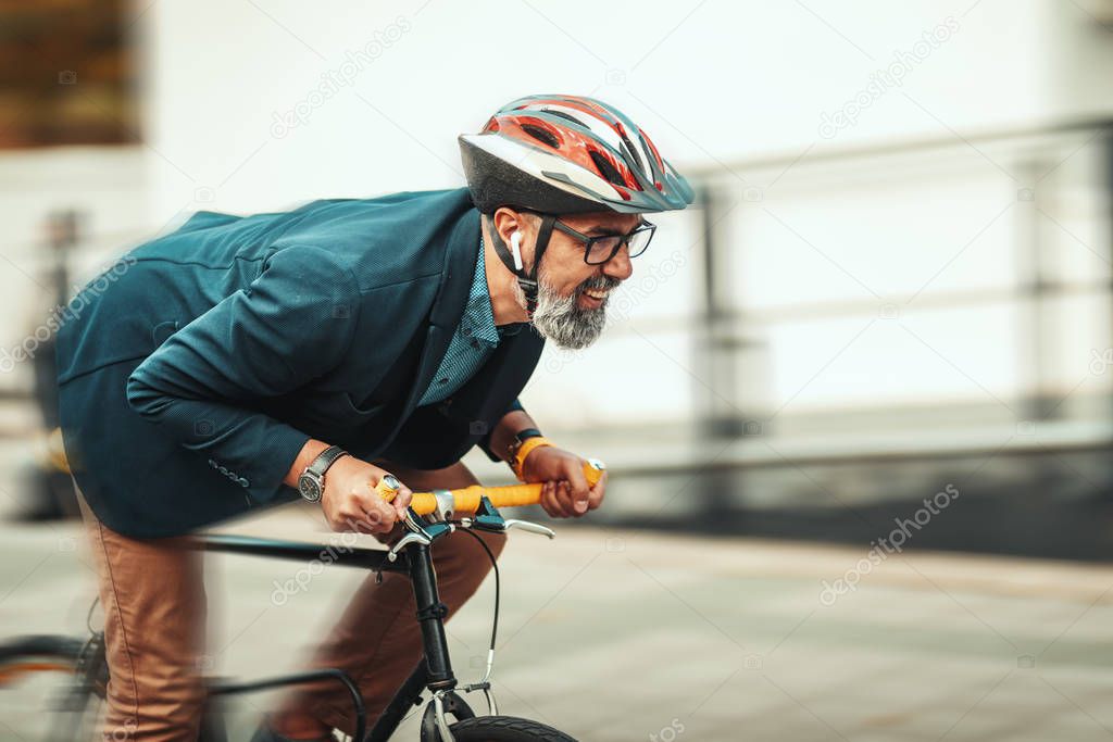 A handsome casual middle-aged businessman is going to the office by bicycle. He is hurrying up because he is late.
