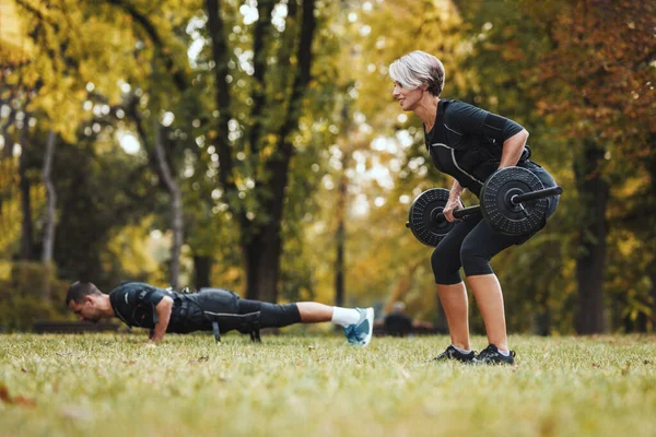 Красивая Женщина Партнер Делают Упражнения Парке Одетые Черный Костюм Электронным — стоковое фото