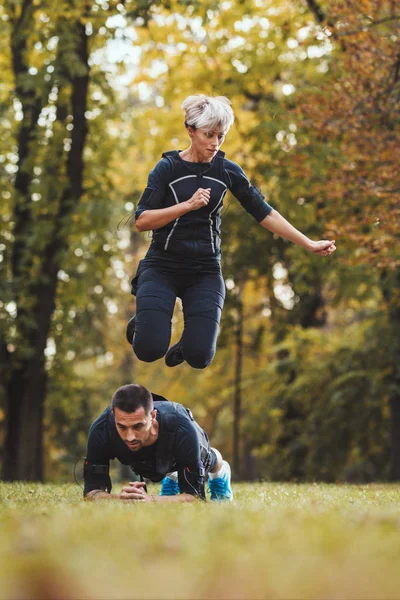 Красивая Женщина Веселый Партнер Делают Упражнения Парке Одетые Черный Костюм — стоковое фото