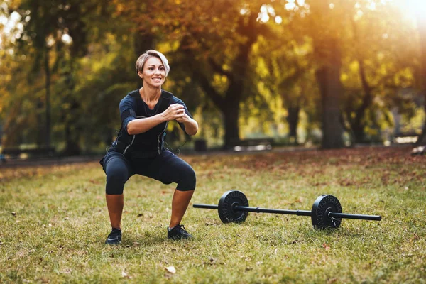 Uma Mulher Madura Muscular Está Fazendo Exercícios Agachamento Parque Vestida — Fotografia de Stock