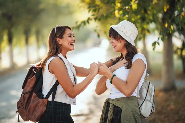 Twee Mooie Jonge Lachende Vrouwen Met Rugzakken Hun Rug Lopen — Stockfoto