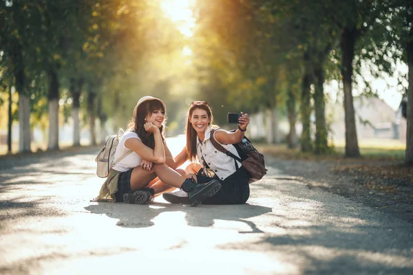 Två Vackra Unga Leende Kvinnor Med Ryggsäckar Ryggen Gör Selfie — Stockfoto