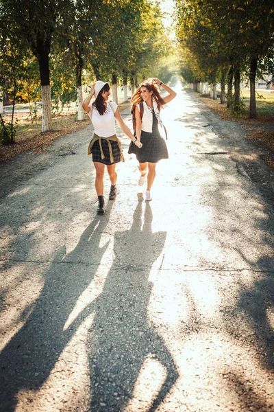 Dwie Piękne Wesołe Młode Kobiety Plecakami Plecach Spacerują Jesienną Słoneczną — Zdjęcie stockowe