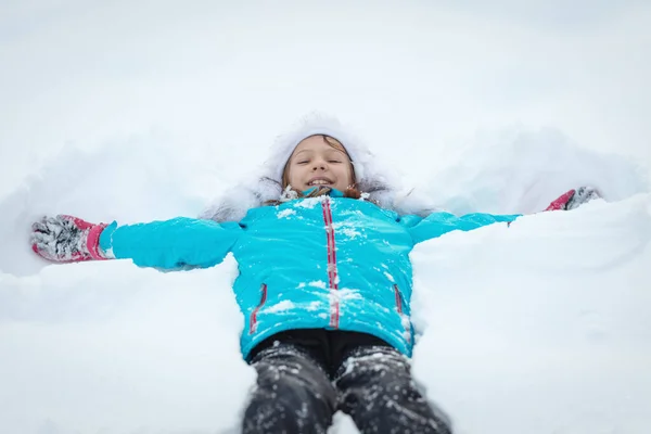 Χαριτωμένο Κοριτσάκι Χειμωνιάτικα Ρούχα Διασκεδάζει Ξαπλωμένη Καθαρό Λευκό Χιόνι — Φωτογραφία Αρχείου