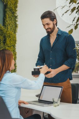 Genç iş arkadaşları başarılı bir gün geçirmek için sabah kahve molası veriyorlar..
