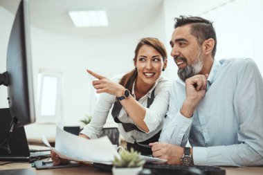 Genç başarılı mühendisler ofiste bilgisayar üzerine yeni bir proje üzerinde çalışırken konuşuyorlar..