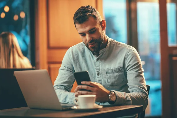 Bel Giovane Sta Leggendo Messaggi Smartphone Lavorando Computer Portatile Seduto — Foto Stock