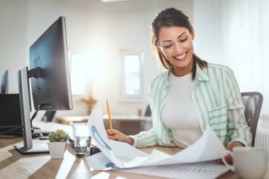 Genç ve başarılı bir bayan tasarımcı ofiste yeni bir proje üzerinde çalışıyor.. 