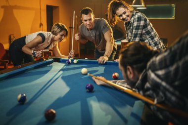 Dört tane gülümseyen neşeli arkadaş işten sonra barda bilardo oynuyorlar. Onlar eğlence aktivitelerine katılırlar..