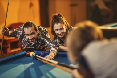 Bir grup güler yüzlü arkadaş işten sonra barda bilardo oynuyorlar. Onlar eğlence aktivitelerine katılırlar..
