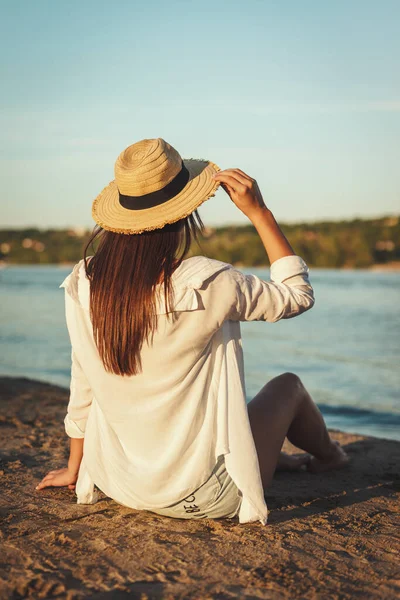 Вид Сзади Молодую Женщину Соломенной Шляпе Отдыхающую Закате Берегу Реки — стоковое фото