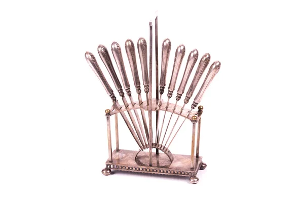 set of silver antique knives on a holder