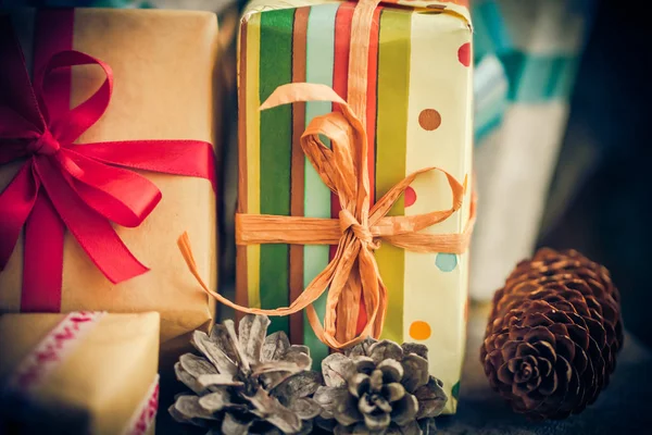 Santa Claus vánoční dárky pakety šišky dřevěný stůl — Stock fotografie