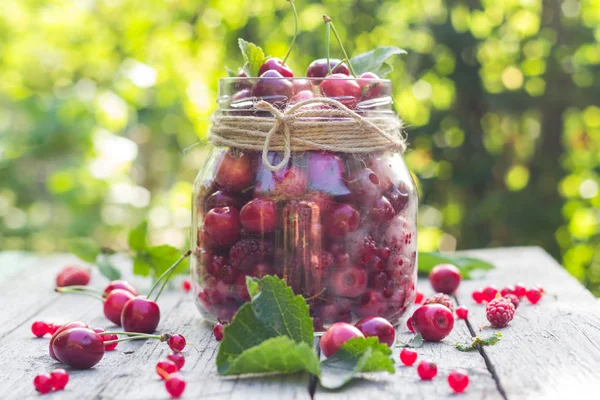 Glass jar full of fruits cherries and raspberries — Stock Photo, Image