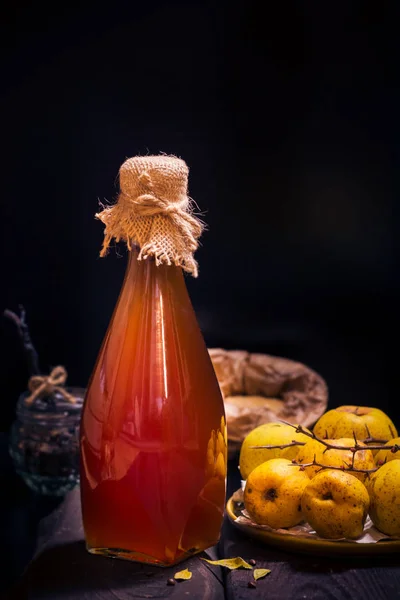 Láhev likéru dřevěný stůl ingredience tinktury ovoce kdoule — Stock fotografie