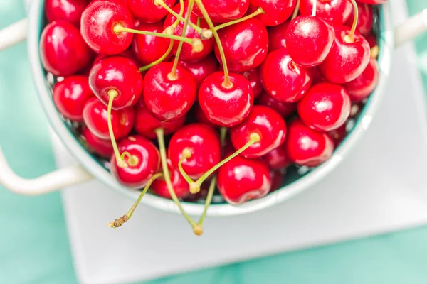 Frische rote Kirschfrüchte grüner Sieb — Stockfoto