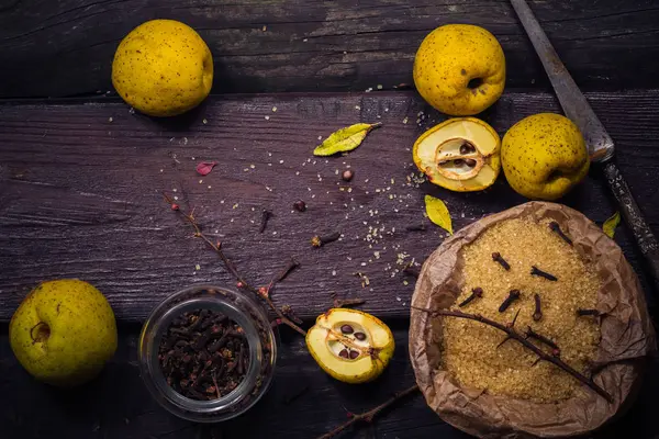 Plody kdoule větvičky cukr hřebíček vanilkové dřevěný stůl — Stock fotografie