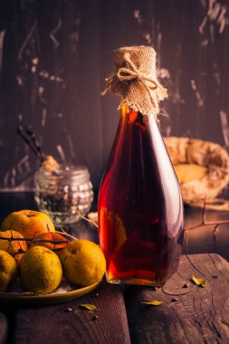 Şişe likörü Ayva tentür malzemelerle ahşap bir masa üzerinde