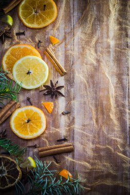 Narenciye ve baharat: dilim limon, portakal, karanfil ve tarçın ile renkli arka plan