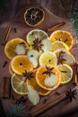 Tıbbi çay için gerekli malzemeler. Citrus ve baharatlar. Limon, portakal, zencefil, karanfil ve tarçın dilimleri..