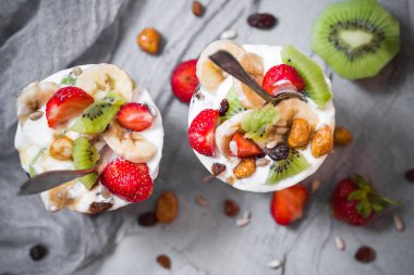 Çilekli yoğurt meyveli tatlı, muz, kivi, kuru üzüm, ayçekirdeği, yulaf ezmesi ve karamelli ceviz.