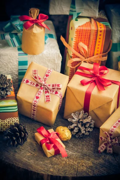 Temps Noël cadeaux festifs paquets pin cônes table en bois — Photo