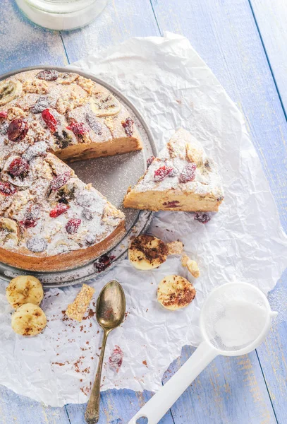 Um bolo de banana fatiado com nozes, gergelim e cranberry em uma madeira — Fotografia de Stock