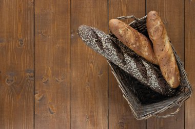 Kahverengi ahşap bir masada sepetin içinde baget.