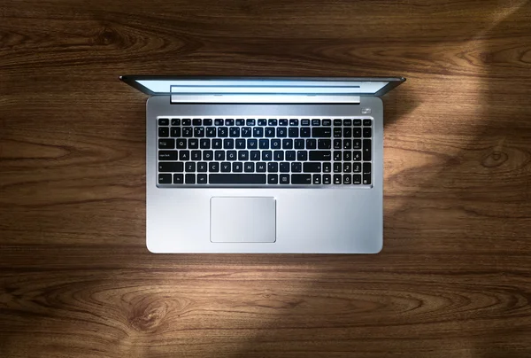 Vista de cerca de la bonita computadora portátil de plata en la parte superior del escritorio de madera — Foto de Stock