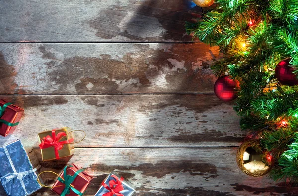Προβολή των φωτισμένο χριστουγεννιάτικο δέντρο και κουτιά δώρων του Μεσονυκτίου ξύλινη πλάτη — Φωτογραφία Αρχείου
