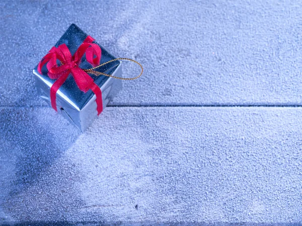 Nahaufnahme der Geschenkschachtel auf schneebedeckter Holzrückseite — Stockfoto