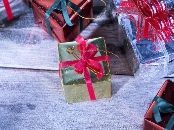 Vista de cerca de cajas de regalo en la parte posterior de madera con nieve —  Fotos de Stock