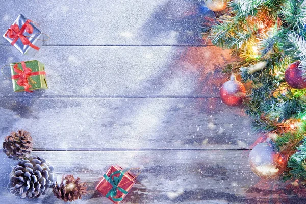 Utsikt över upplyst julgran och presentaskar på insnöade trä tillbaka — Stockfoto