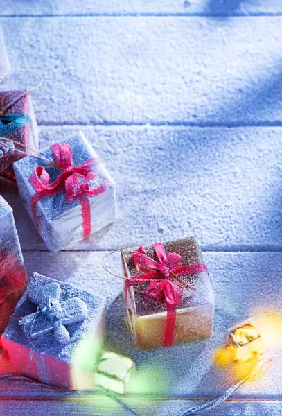 Nahaufnahme von Geschenkboxen auf schneebedeckter Holzrückseite — Stockfoto