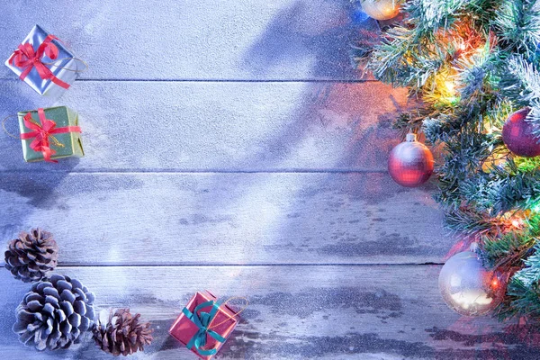 Utsikt över upplyst julgran och presentaskar på insnöade trä tillbaka — Stockfoto