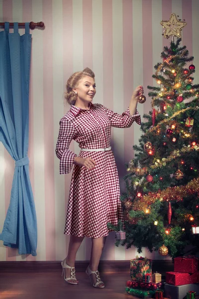 Retrato de mujer joven agradable que cuelga alrededor del árbol de Navidad en la víspera de x-mas — Foto de Stock