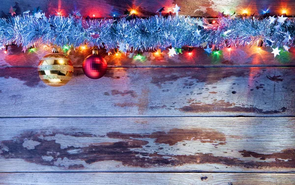 Close up view of christmas tree toys and lights on wooden back — Stock Photo, Image