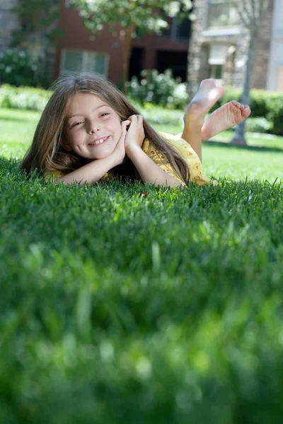 Küçük kız yaz ortamında çim döşeme portresi — Stok fotoğraf