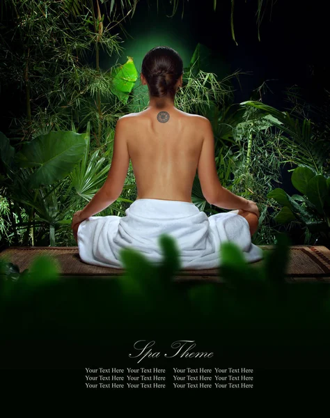 Uitzicht op de mooie jonge vrouw mediteren in een spa omgeving — Stockfoto